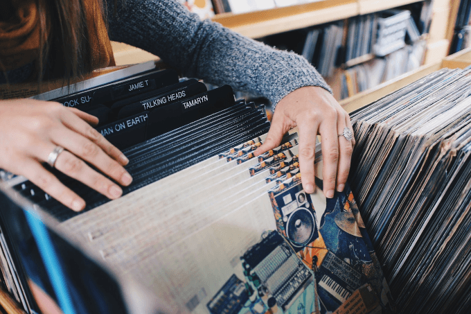 A person sorting through vinyl records stored in a box